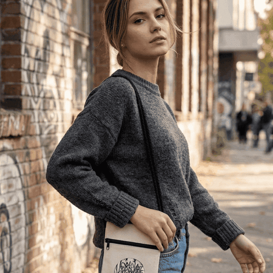 Stylish gray sweater worn by a model in an urban setting, showcasing casual fashion.