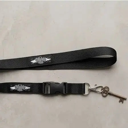 Black key lanyard with a silver key attachment and decorative design.