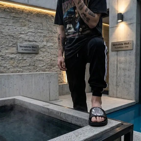 Stylish Black Slide Sandals worn by a person near a modern pool area.