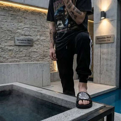 Stylish Black Slide Sandals worn by a person near a modern pool area.