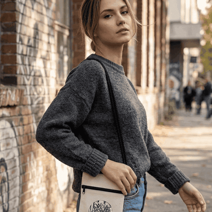 Stylish gray sweater worn by a model in an urban setting, showcasing casual fashion.