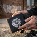Graphic Wallet featuring unique design and durable material, held by a tattooed hand.