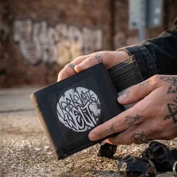 Graphic Wallet featuring unique design and durable material, held by a tattooed hand.